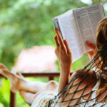 Vrouw leest boek in hangmat